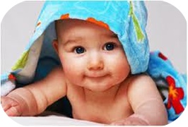 Smiling baby lying under a soft blanket