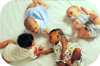 Infants playing together on a blanket