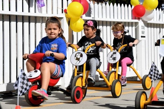 Children racing tricycles during Physical Fitness Week